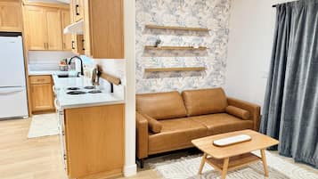 Una cocina moderna con armarios de madera, encimera blanca y estufa integrada.