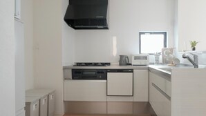 Una cucina compatta con forno a microonde, fornello e lavastoviglie.