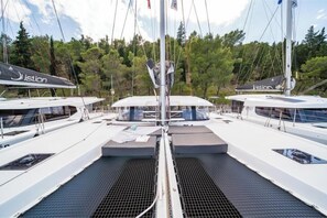 A yacht deck with multiple seating areas, a central table, and a mast. - Excess 14 A/C & GEN & WM - First Journey (Skradin)