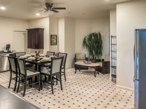 A modern kitchen with a dining area, a ceiling fan, and a large potted plant. - Serrano Village Villa (El Dorado Hills)