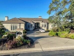 A two-story house with a driveway and a parked car. - Serrano Village Villa (El Dorado Hills)