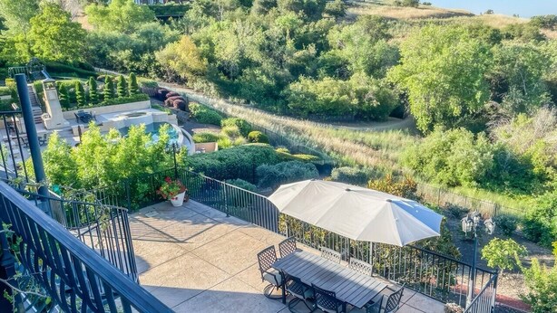 A patio area with a table and chairs, surrounded by a fence and greenery. - Serrano Village Villa - El Dorado Hills (El Dorado Hills)