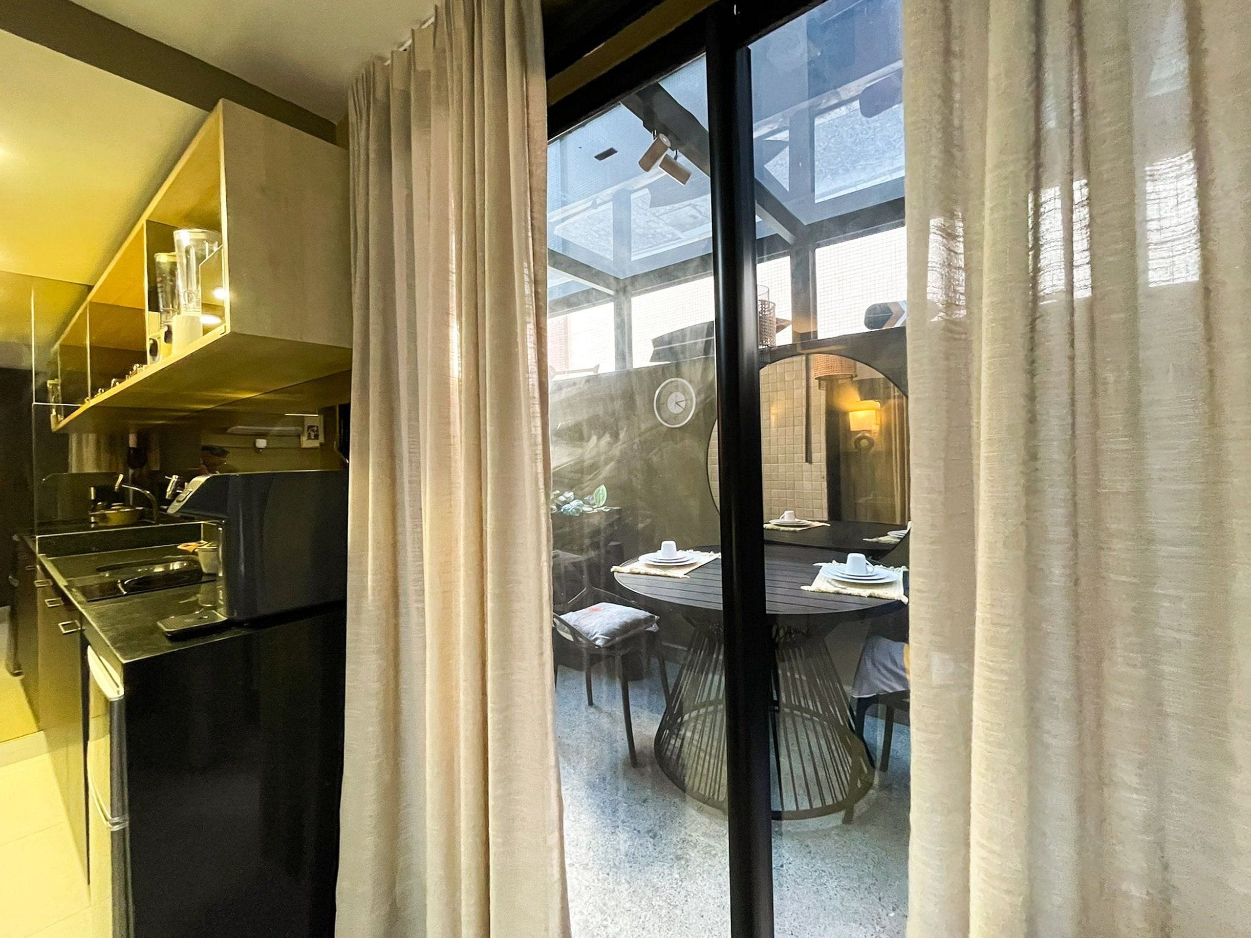 A modern kitchen with stainless steel appliances and a dining area with a round table and chairs.