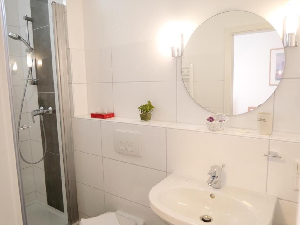 A bathroom with a shower, a sink, and a mirror.