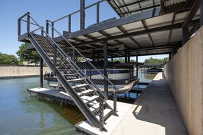 A boat dock with a metal staircase leading to a covered area. - *New* The Marbella on LBJ | Private Pool, Boat Slips & Lift, Sleeps 19 🌅 (Kingsland)