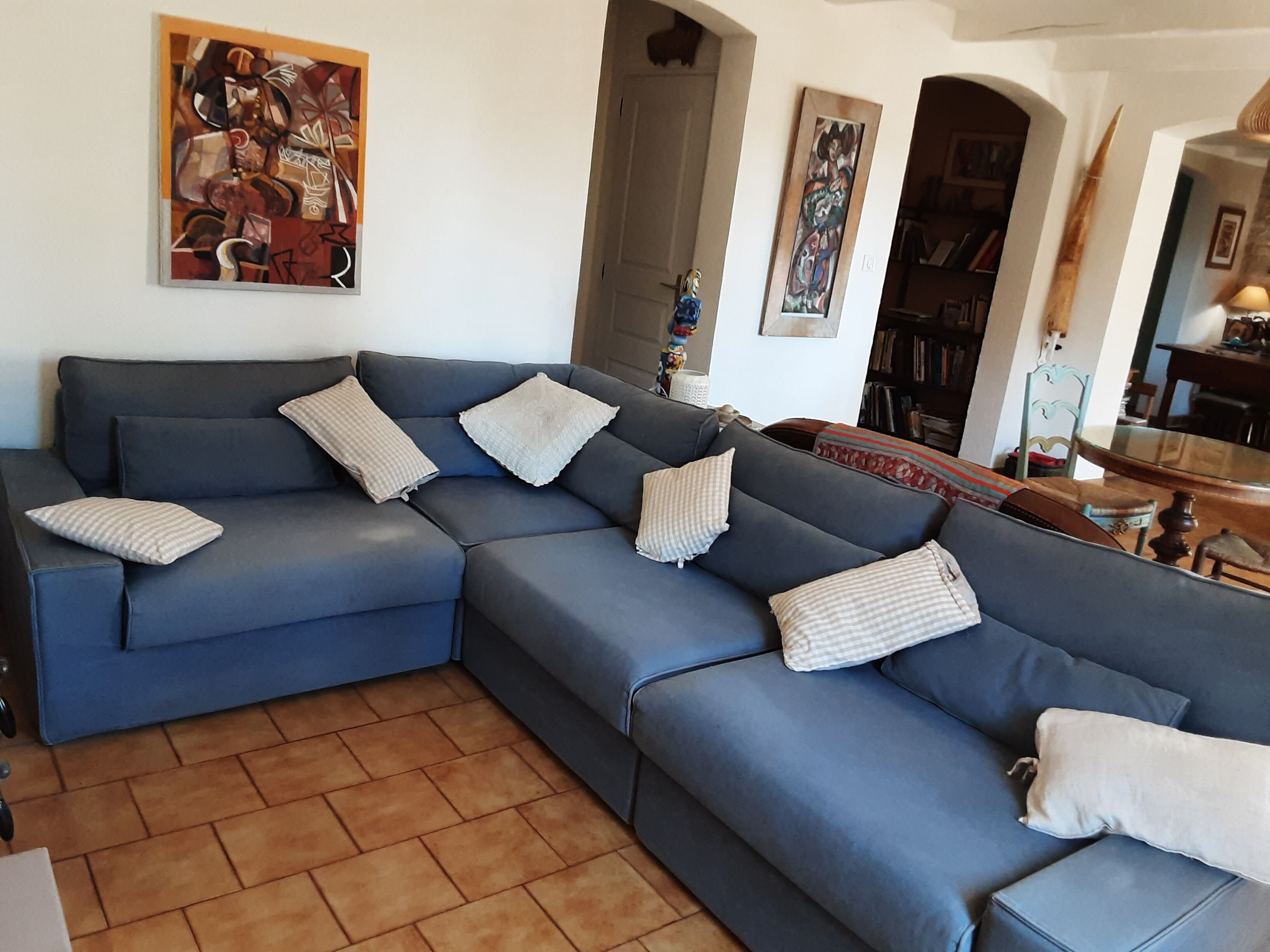 Een moderne woonkamer met een blauwe modulaire bank, een salontafel en een boekenkast.