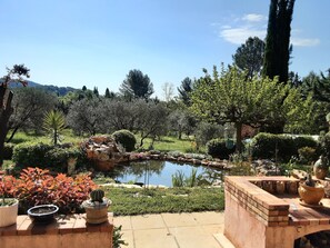 A garden with a pond, various plants, and a brick structure. - Villa with Pool on a 6,200-square-meter Estate in Green Provence. Sleeps 6 to 10 people. (Draguignan)