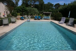 A rectangular swimming pool with clear water, surrounded by lounge chairs and a pergola. - Villa with Pool on a 6,200-square-meter Estate in Green Provence. Sleeps 6 to 10 people. (Draguignan)
