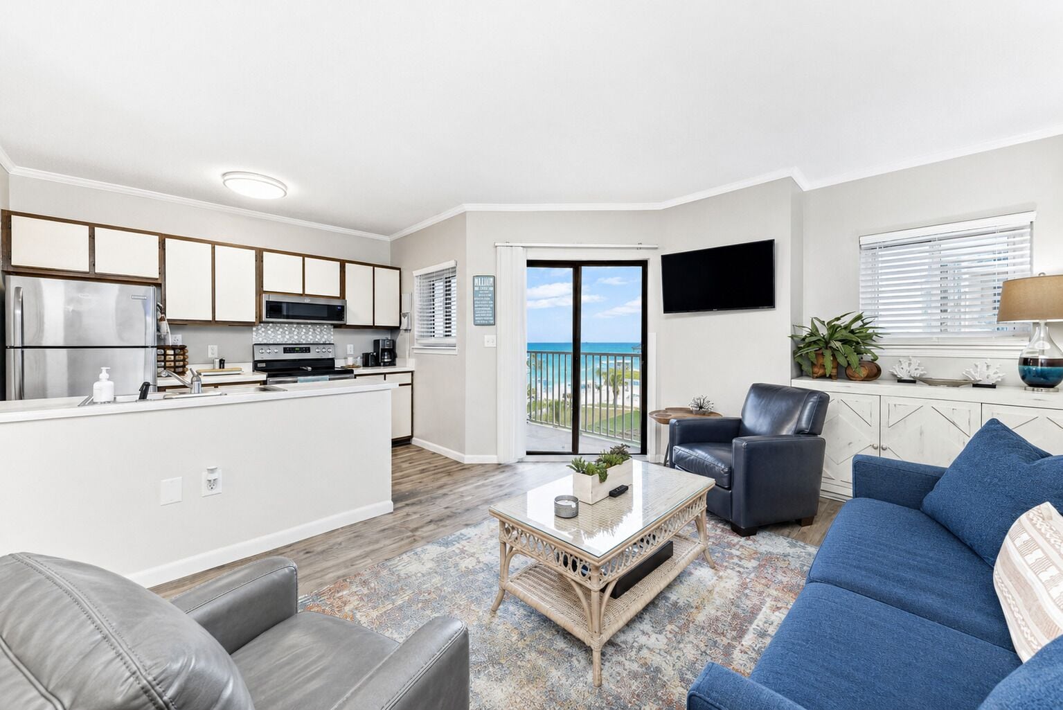 A modern living space with a kitchen, a dining area, and a balcony with a view.