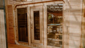 Une cabane en bois dotée d’une grande porte-fenêtre coulissante et d’une porte plus petite, toutes deux munies de poignées en métal.