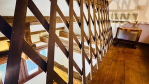 A wooden attic with a sloped ceiling and a wooden railing. - Rialto Vacations with Air Conditioning and Shared Kitchen (Venice)