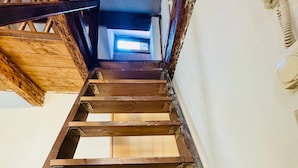 A wooden staircase with a view of a room at the top. - Rialto Vacations with Air Conditioning and Shared Kitchen (Venice)