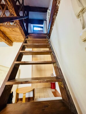 Eine Holztreppe mit Blick auf einen Raum oben.