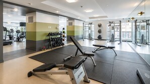 A gym with exercise equipment, a bench, and a rack of dumbbells. - Bright 1BR at Motion | Prime Downtown Location (Toronto)