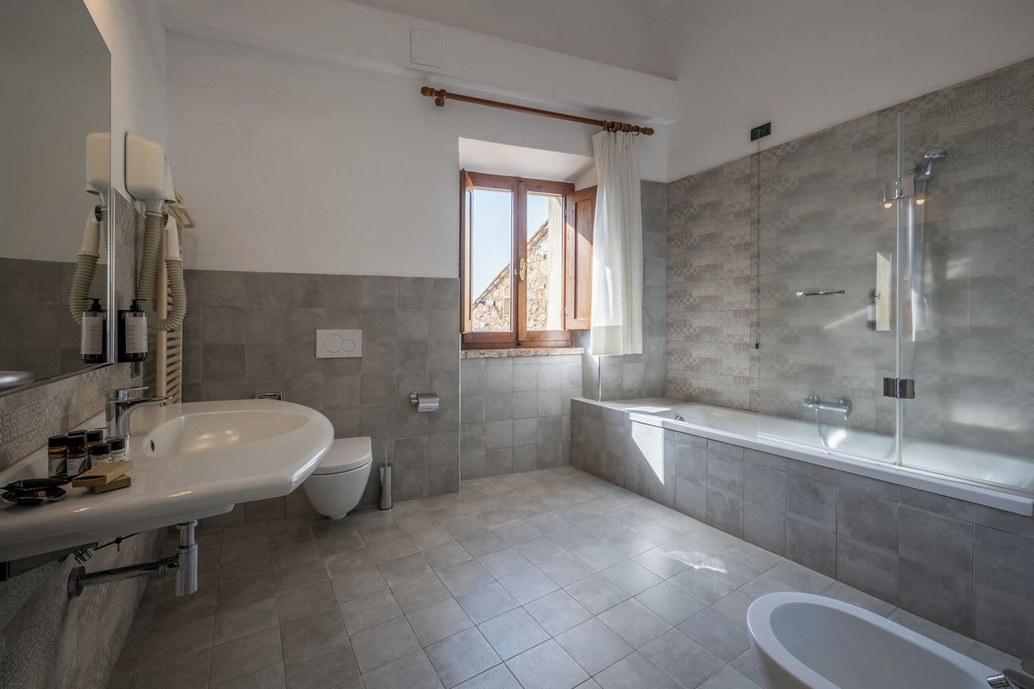 A modern bathroom with a large bathtub, a separate shower area, and a toilet.