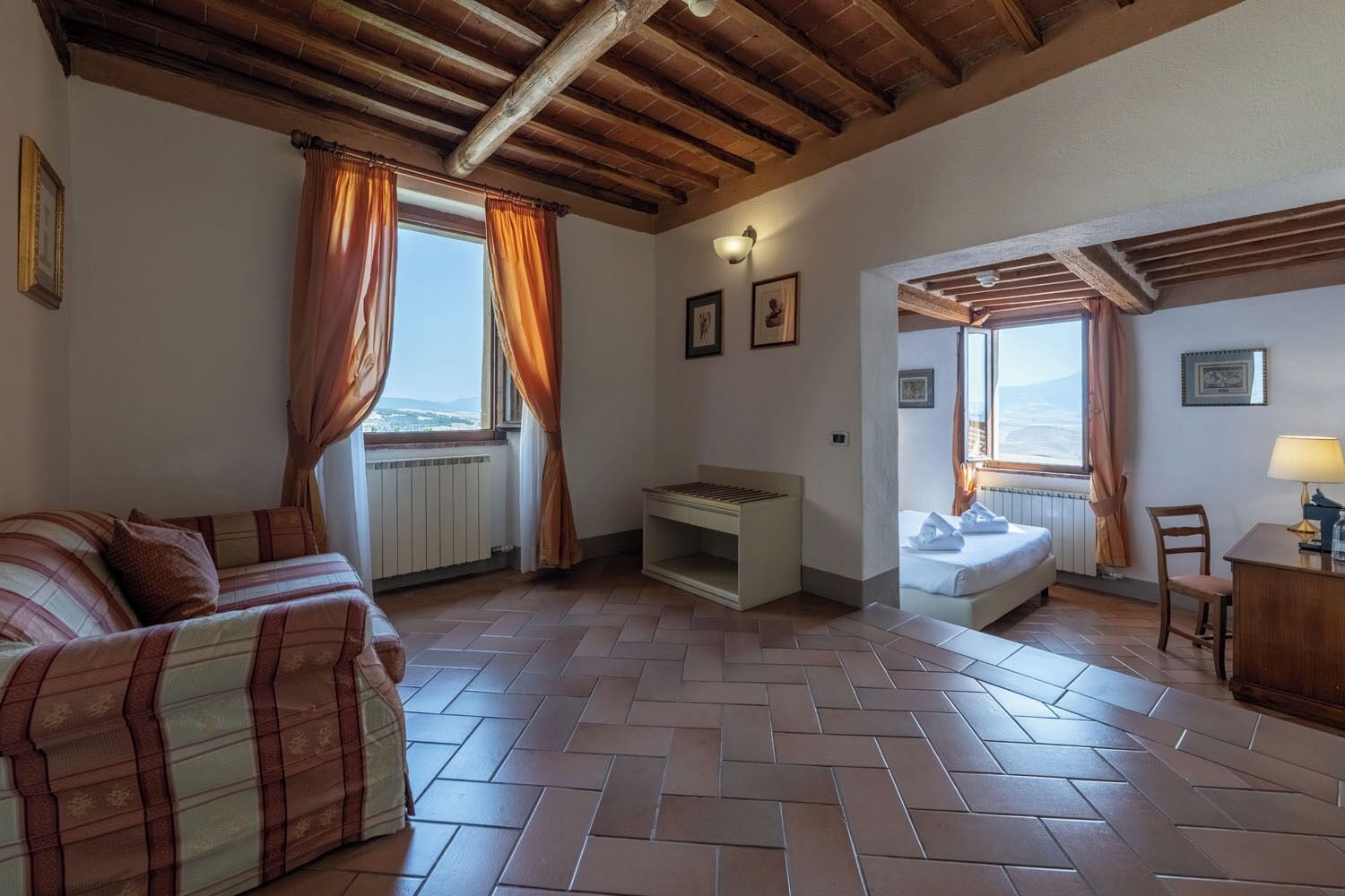 Una habitación con sofá, cama, mesa y vistas al exterior.