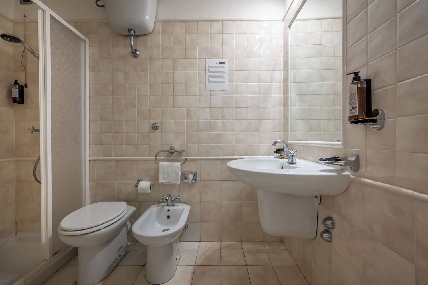 Ein Badezimmer mit Toilette, Bidet, Waschbecken und Dusche.