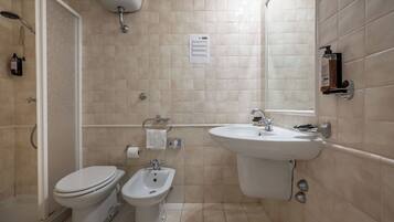 Ein Badezimmer mit Toilette, Bidet, Waschbecken und Dusche.