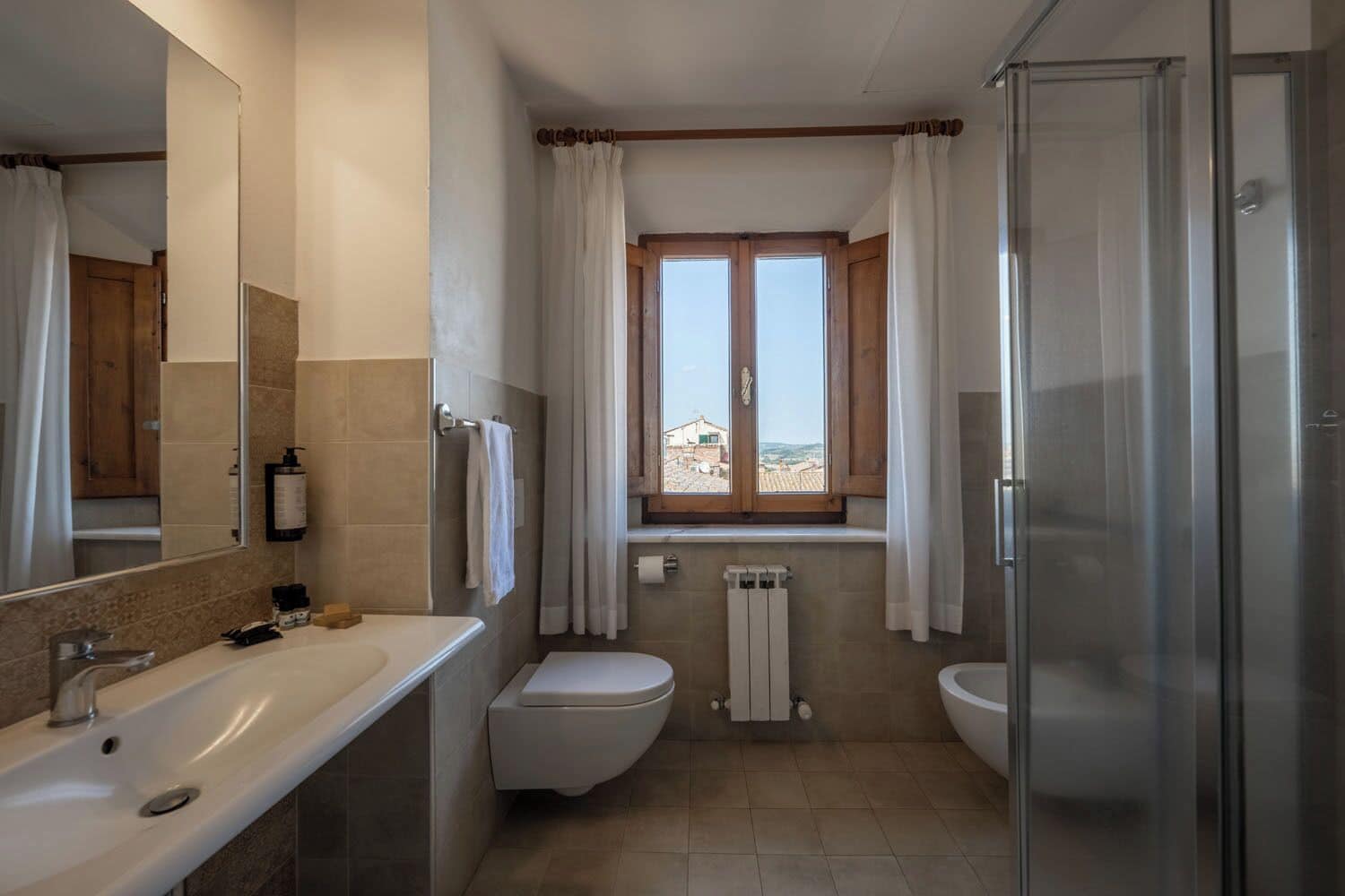 A bathroom with a shower, a toilet, and a sink.