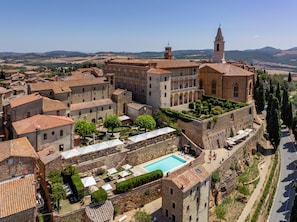Un pueblo histórico con una iglesia destacada, un patio con piscina y edificios escalonados.