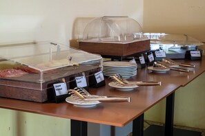 Un montaje de buffet con diferentes alimentos y utensilios.