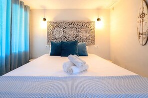 Ein Hotelzimmer mit einem großen Bett, einem dekorativen Kopfteil, zwei Kissen, einer Wanduhr und einer Kompassdekoration.
