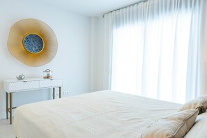 Ein Schlafzimmer mit einem großen Bett, einem Nachttisch mit Dekoration und einer Wandleuchte.