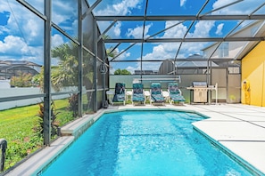 A swimming pool with a glass enclosure, lounge chairs, and a barbecue area. - 4 BDR South-Facing Disney Retreat (Kissimmee)