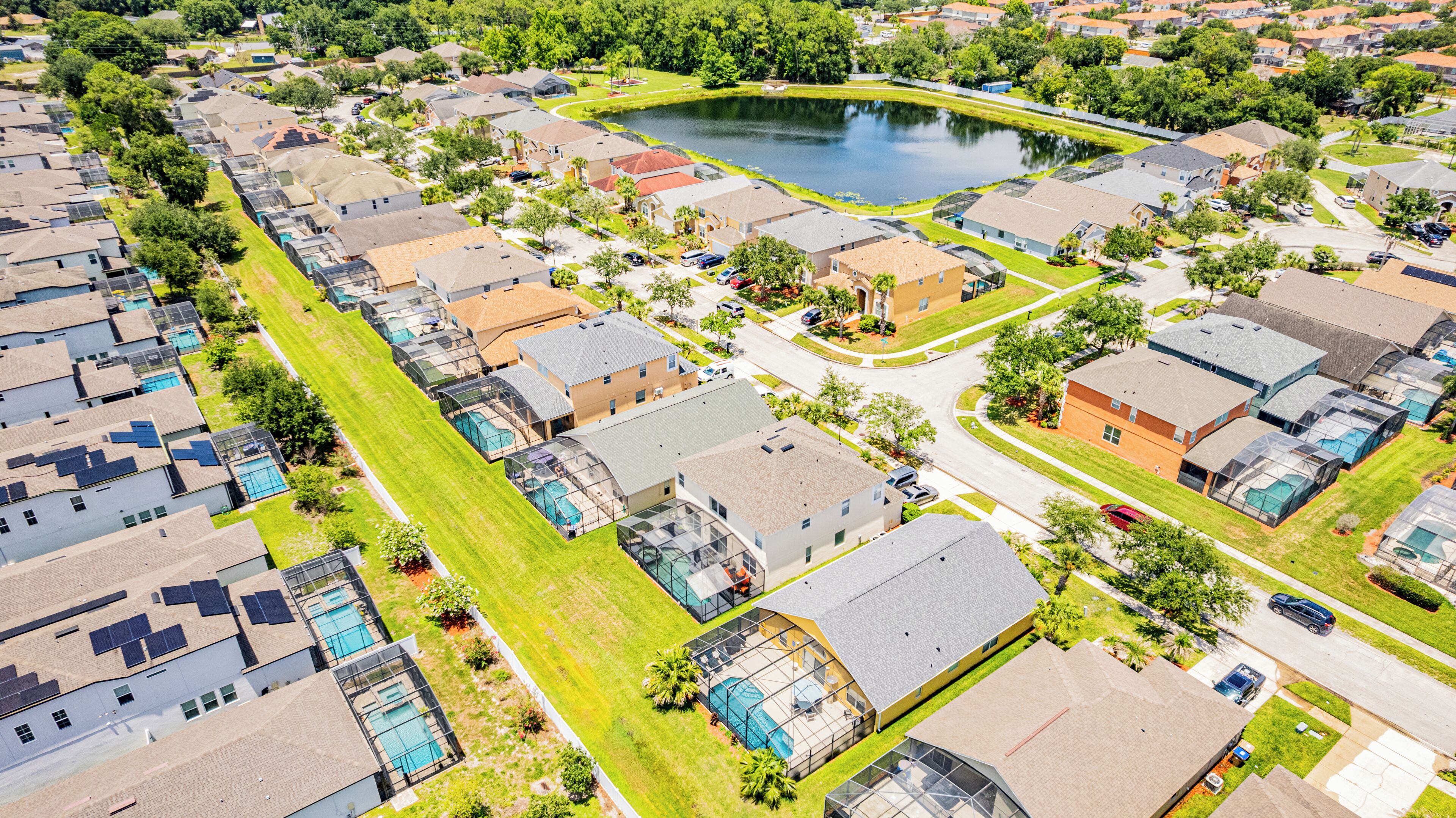 A residential area with houses, a central road, and a small lake.