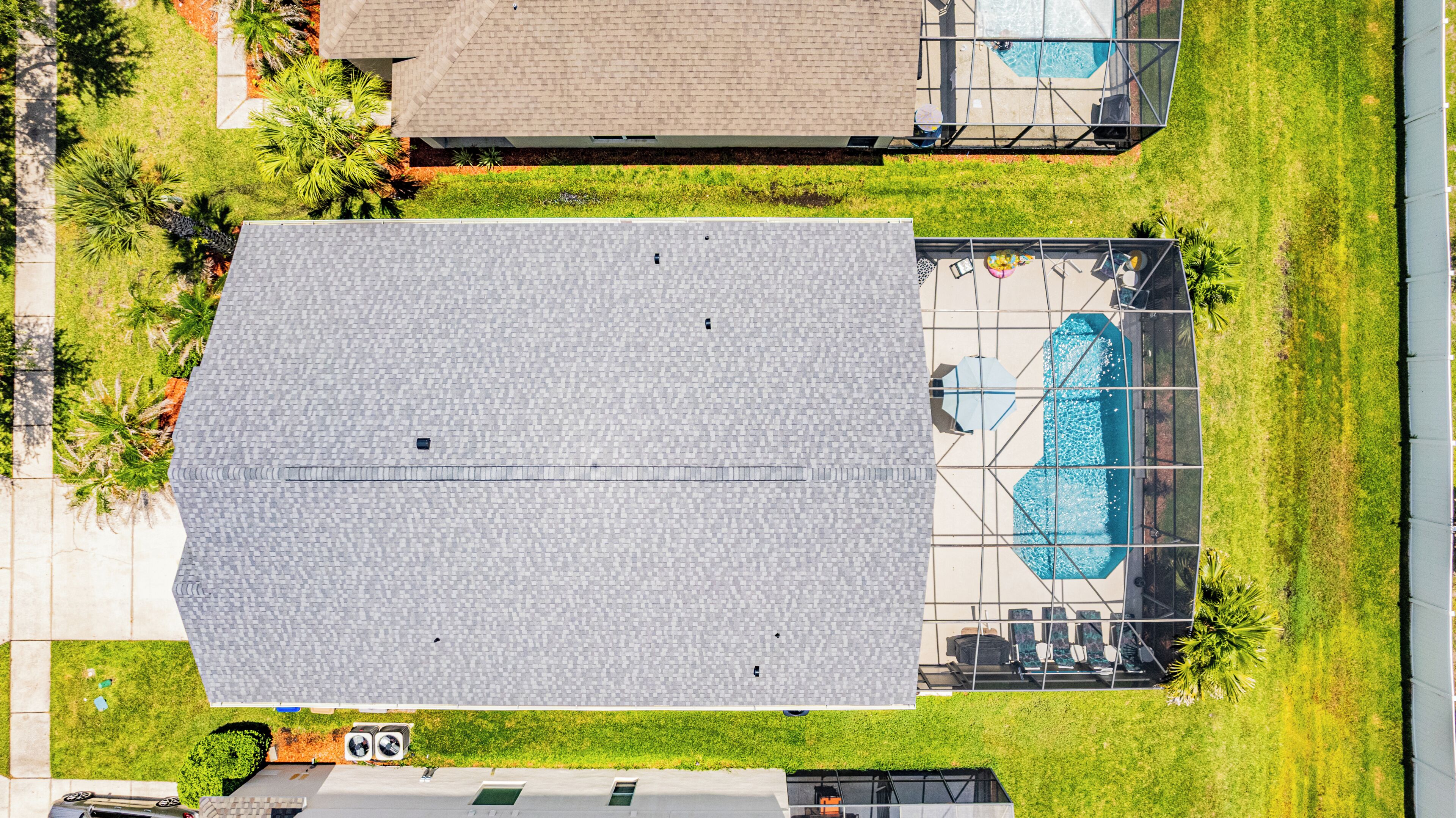 Vista aérea de una zona residencial con una gran estructura cubierta, piscina y vegetación circundante.