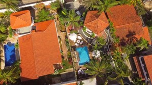 A residential area with multiple houses, a swimming pool, and palm trees. - Italcaribe Village (Paraguachí)