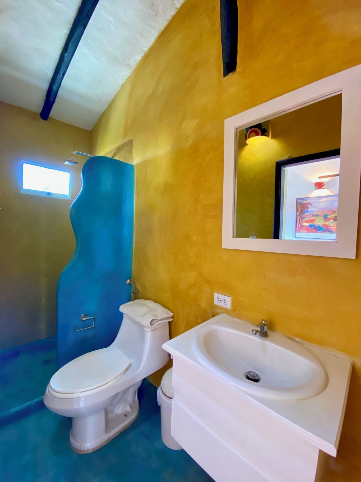 A bathroom with a toilet, sink, and shower.