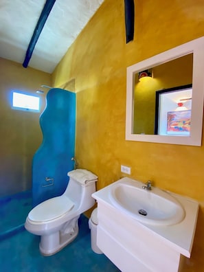 Une salle de bain avec des toilettes, un lavabo et une douche.