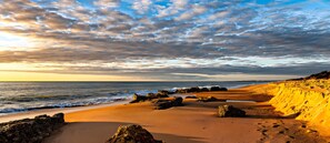 A beach with a clear sky, waves, and rocky outcrops. - Margarita Penthouse Conil Center – Balcony & Air Conditioning (Conil de la Frontera)
