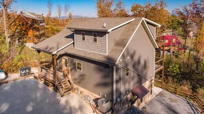Ein zweistöckiges Haus mit überdachter Veranda und Garage.