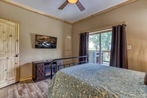 A bedroom with a bed, a fireplace, a painting, and a balcony with curtains. - Sleeps 8, Hot Tub, Fire Table, Sunset Decks, 4 Mi to Downtown Gatlinburg (Gatlinburg)