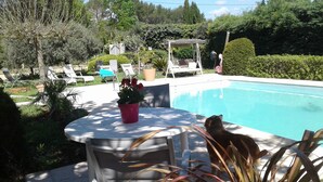 A poolside area with a table, chairs, and a potted plant. - Provencal-style farmhouse with charm, swimming pool, and landscaped grounds on 6,200 m² (Draguignan)