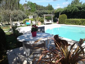 A poolside area with a table, chairs, and a potted plant. - Provencal-style farmhouse with charm, swimming pool, and landscaped grounds on 6,200 m² (Draguignan)