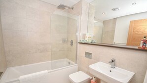 Une salle de bain moderne avec une douche à parois de verre, une baignoire blanche, des toilettes et un lavabo.