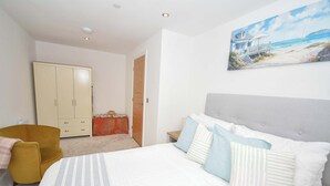 Une chambre à coucher avec un lit, une armoire, une chaise et un tableau au mur.