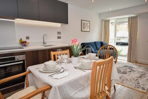 A modern kitchen with a dining area set for a meal. - Modern 1 Bed Apartment in Central Leeds - Sleeps 3 (Leeds)