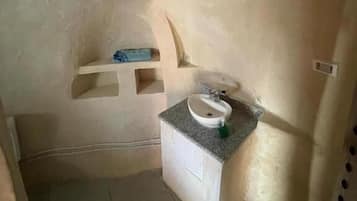Un baño pequeño con lavamanos, espejo y perchero para toallas.