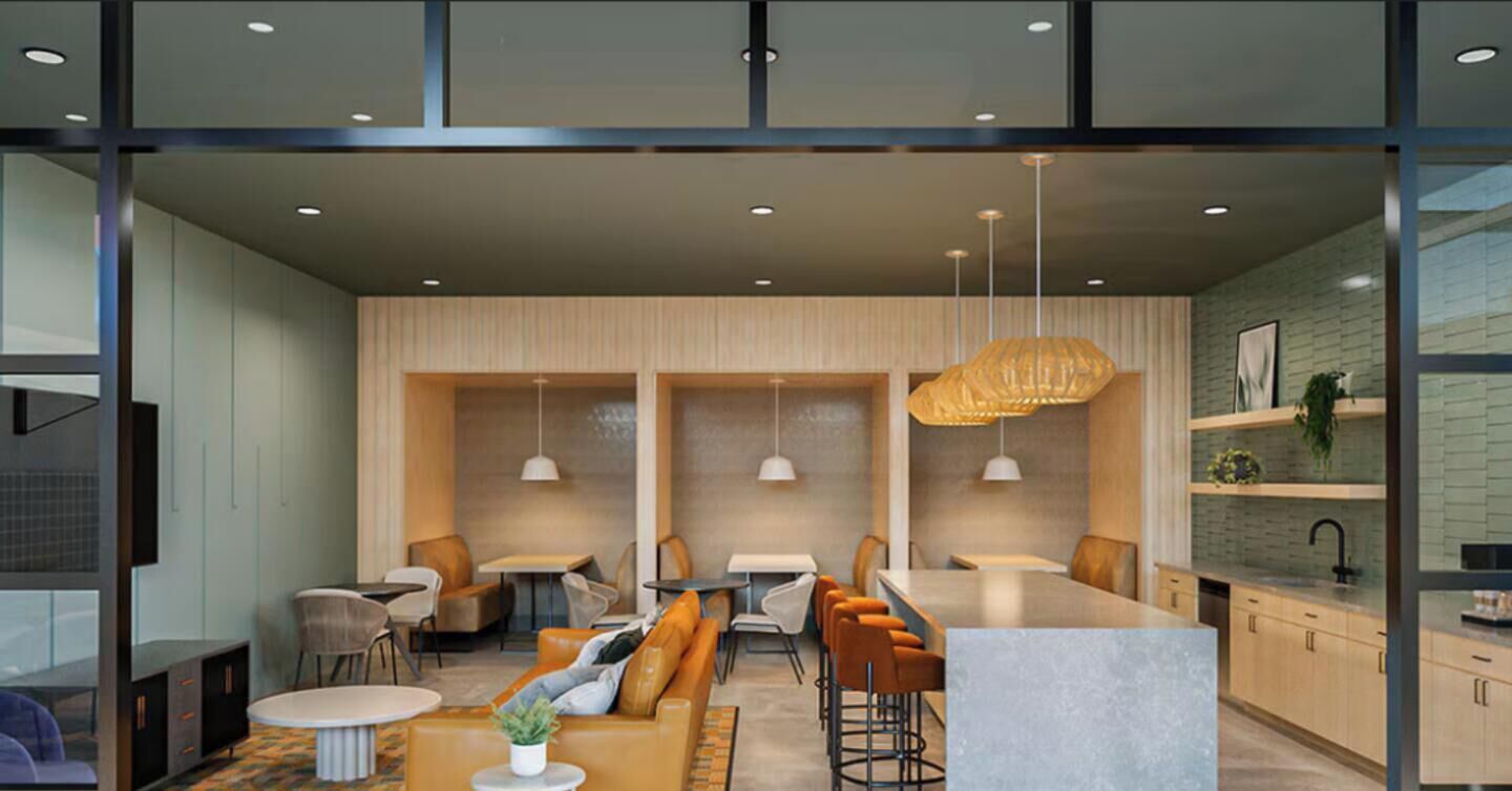 A modern interior with a bar area, seating, and a kitchen visible through glass partitions.