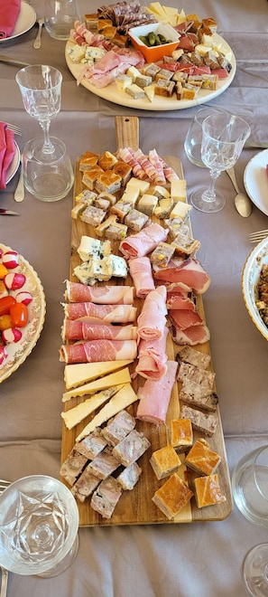 A long wooden board with various types of cheese, cured meats, and pâté. - Guest Room 'Chambre Châtaigneraie' with Terrace and Private Jacuzzi (Soulages)
