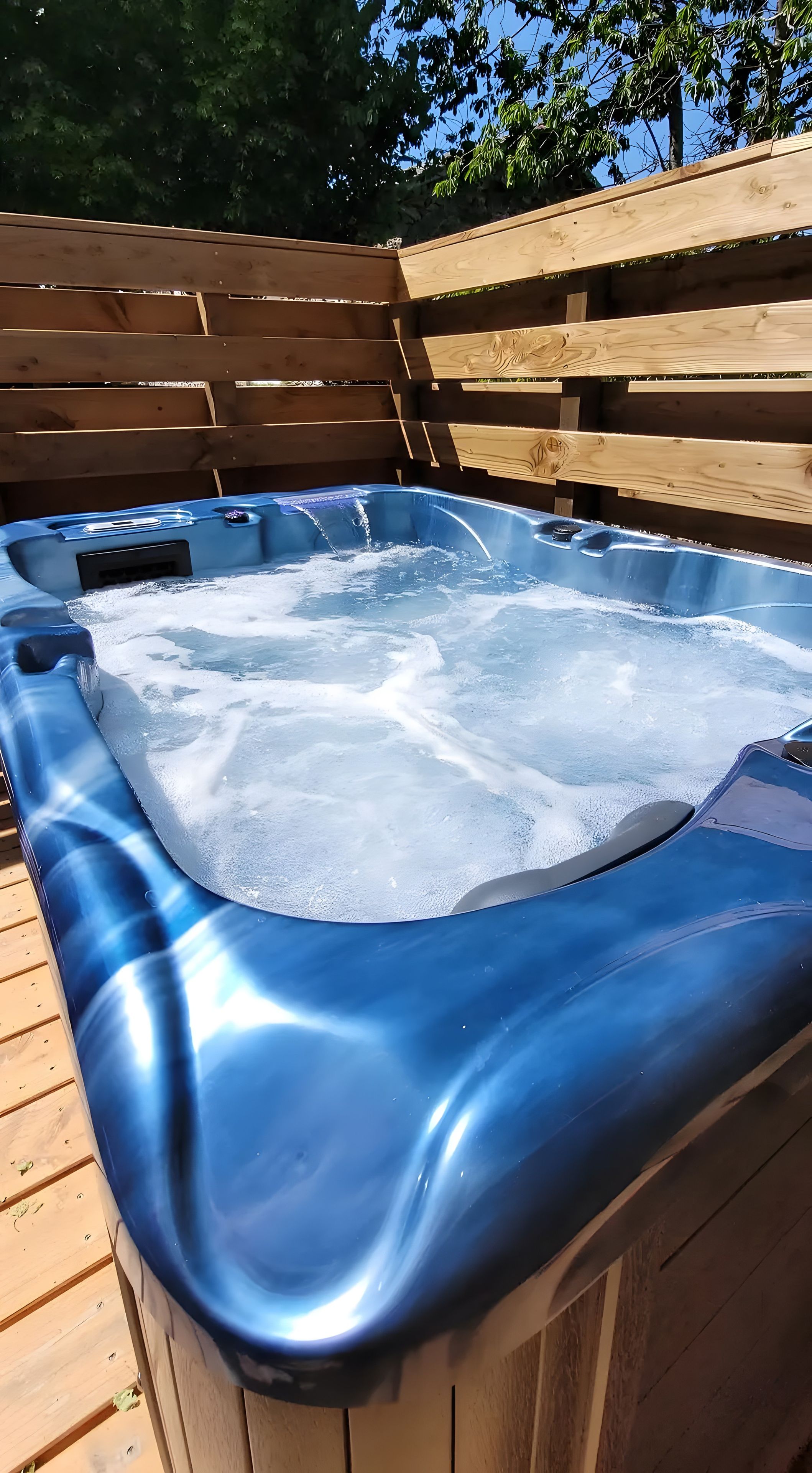 A hot tub with a wooden deck surrounding it.