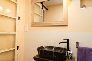 A bathroom with a black vessel sink, a mirror, and a purple towel. - Apartment 'La Morada De La Cerveza Standard' with Balcony, Wi-Fi and Air Conditioning (Villena)