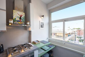 Eine moderne Küche mit Gasherd, einem Fenster mit Stadtblick und einem dekorativen Schild über dem Herd.