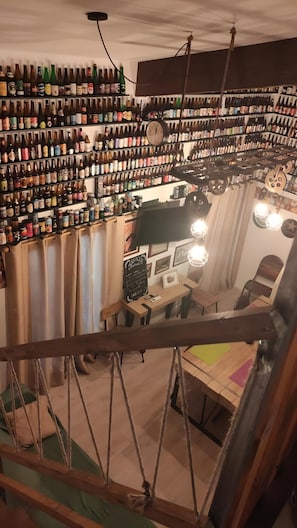 A room with a high ceiling, a clock, and shelves filled with bottles.