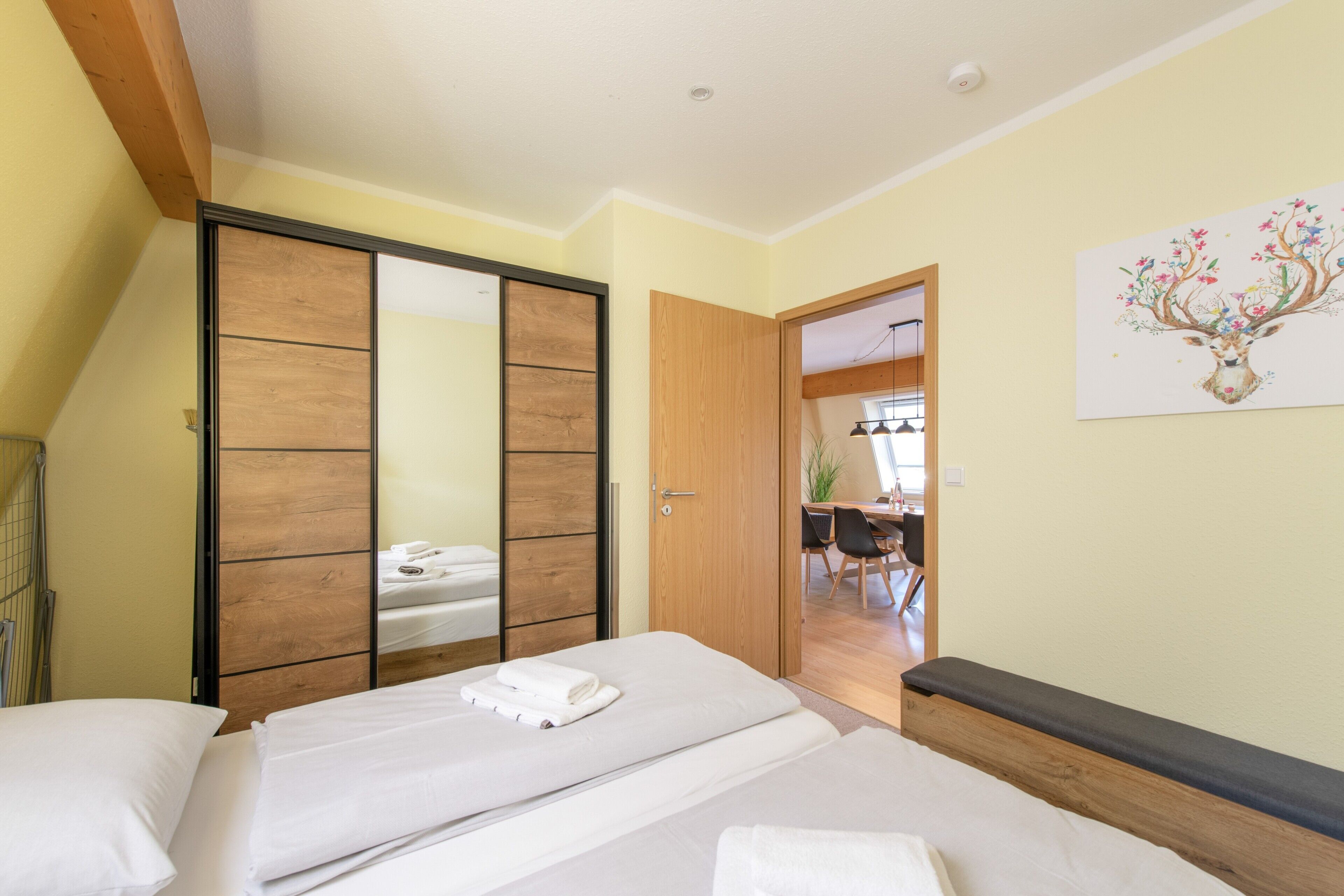 Un dormitorio con cama, armario y puerta que da a un comedor.
