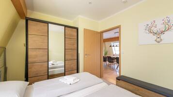 Un dormitorio con cama, armario y puerta que da a un comedor.